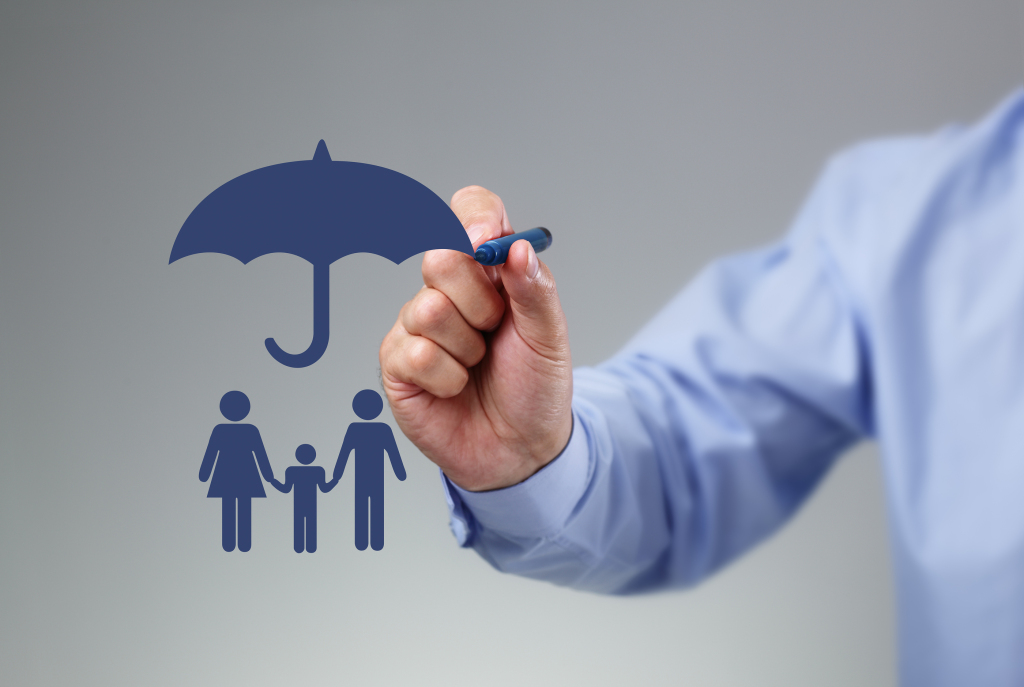 Businessman hand drawing an umbrella above a family concept for